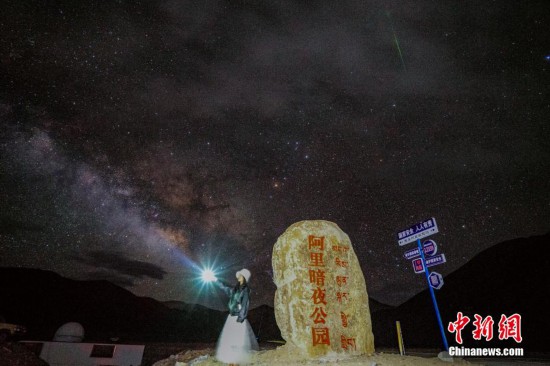圖為6月20日晚,游客“打卡”西藏阿里暗夜公園,天上是銀河與流星(右上角)。曹枝清 攝