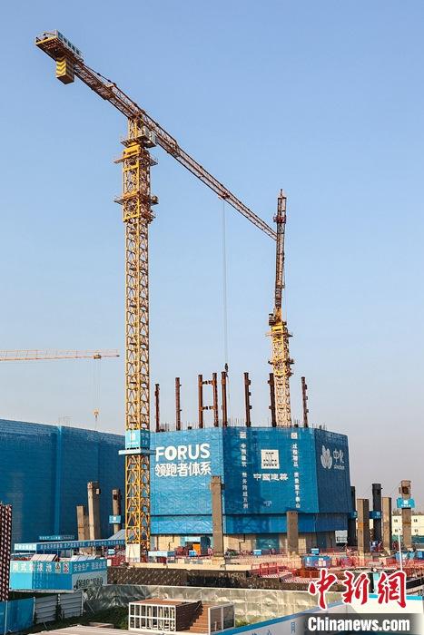 從完成頂層設(shè)計(jì)到如火如荼大規(guī)模建設(shè)，六年來(lái)，雄安新區(qū)如春天的竹子一般拔節(jié)生長(zhǎng)，這座承載千年大計(jì)的“未來(lái)之城”已雄姿初顯。從“一張白紙”開(kāi)始著墨，如今的雄安新區(qū)已是濃墨重彩的“山水畫(huà)”。<a target='_blank' href='/'>中新社</a>記者近日走訪了雄安新區(qū)多地，從“藍(lán)綠金”三色感受這座“未來(lái)之城”的巨大變化。圖為7月19日，河北雄安新區(qū)，中國(guó)中化總部基地項(xiàng)目施工現(xiàn)場(chǎng)。 <a target='_blank' href='/'>中新社</a>記者 易海菲 攝