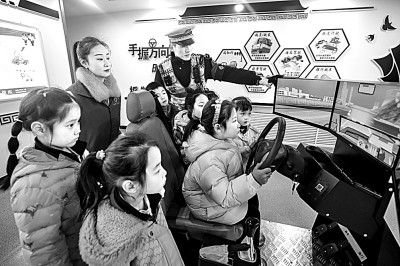 山東省榮成市公安局道路交通安全宣傳教育基地，交警帶領(lǐng)小學(xué)生現(xiàn)場體驗?zāi)M駕駛。新華社發(fā)